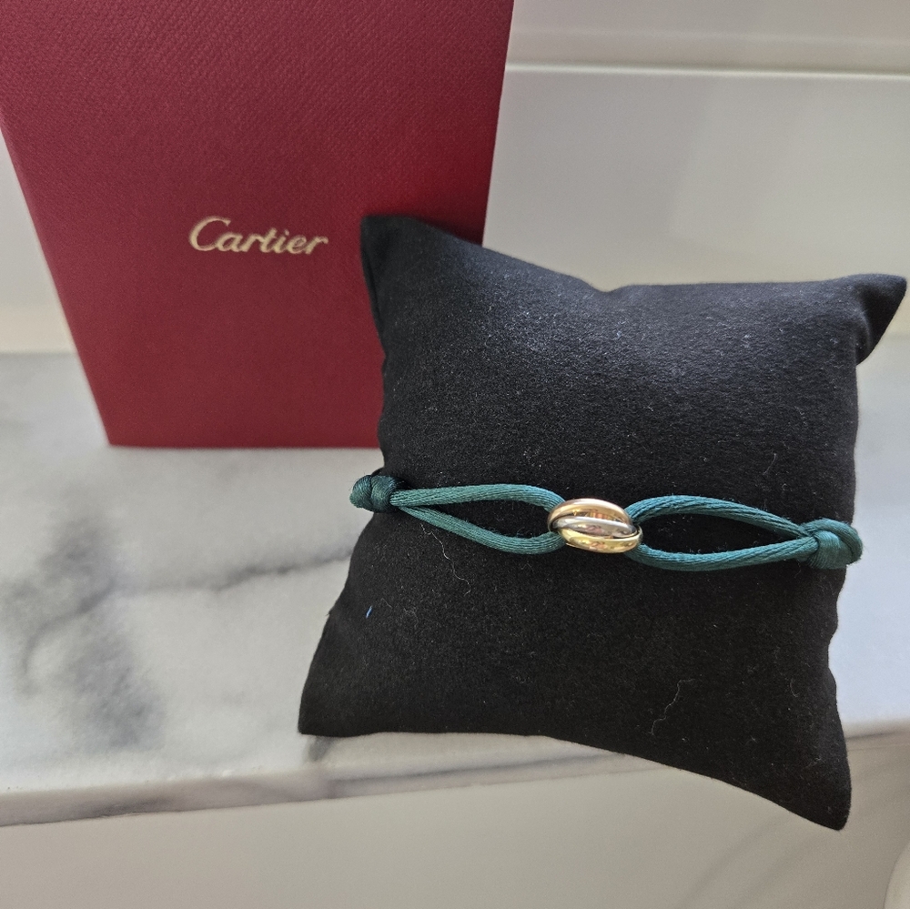 CARTIER authentic Trinity bracelet on silk cord, 18 karat gold.